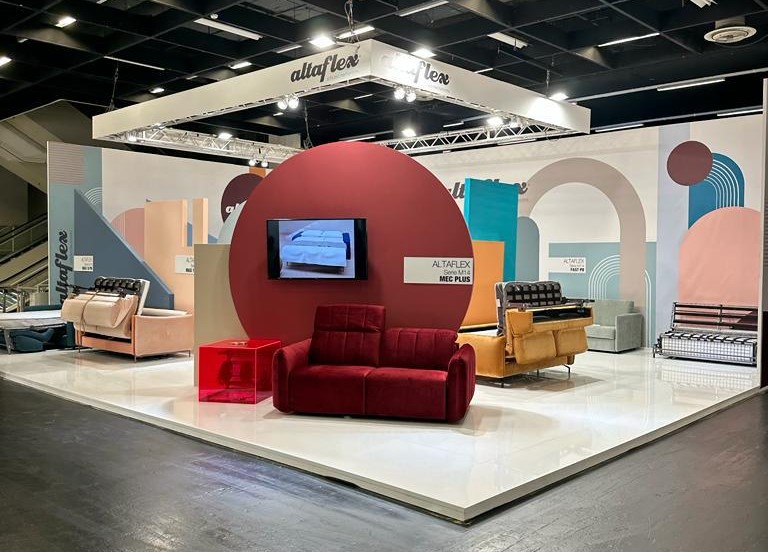 Stand fieristico Altaflex Interzum 2023 Colonia - Vista frontale dell'allestimento con illuminazione scenografica e logo retroilluminato, esempio di excellence in exhibition design